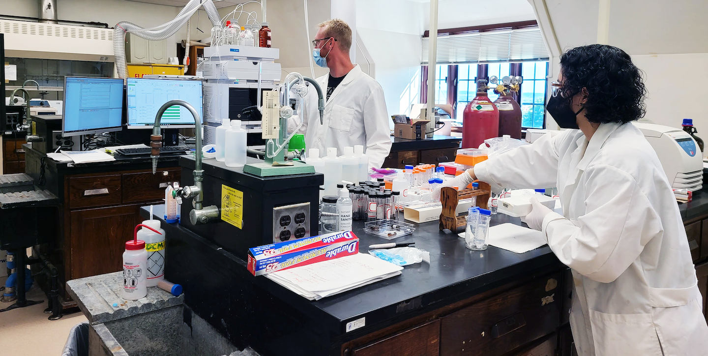 two men standing in a lab with scientific equipment